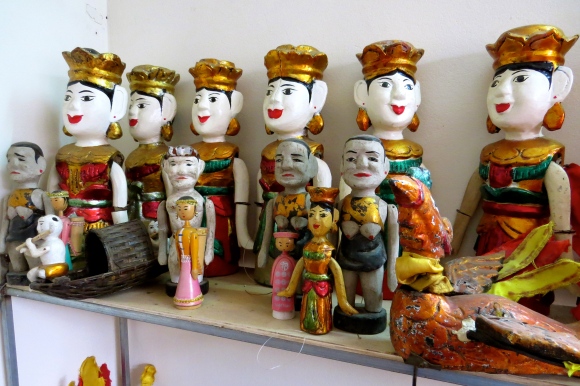 Hand-carved water puppets line the shelves of Phan Liem's home