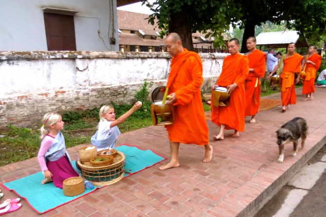 Zoe offers a handful of rice to each monk
